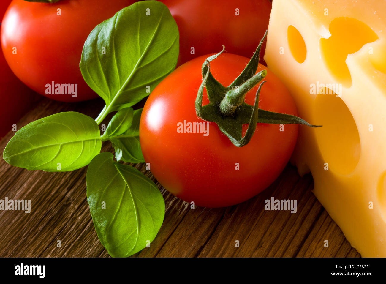 Tomaten, Basilikum und Käse auf alten Holzbrett Stockfoto