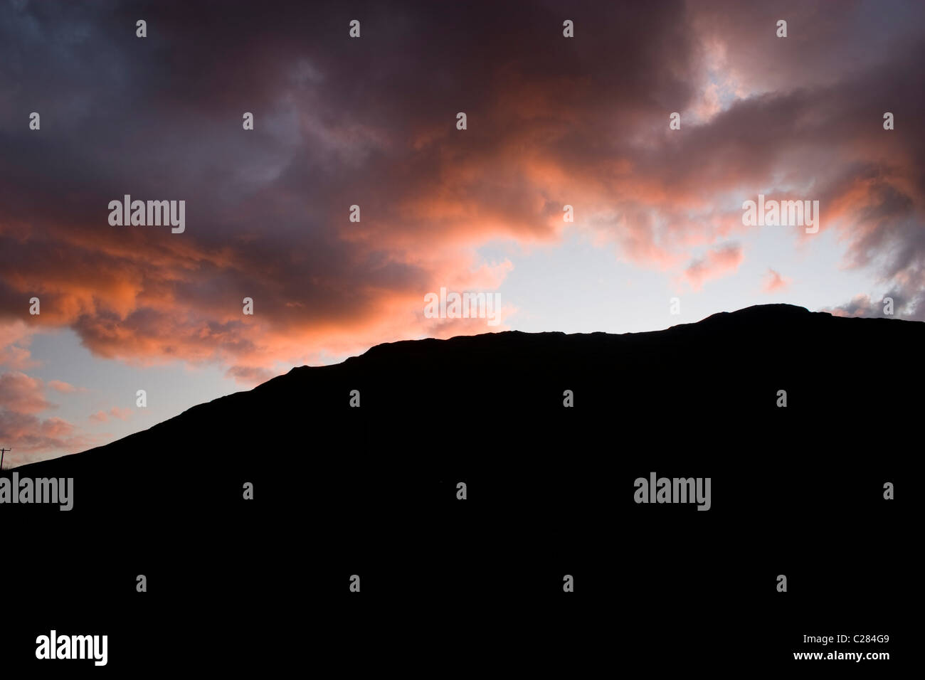 Sonnenuntergang Berge Schottlands Hügel rote Wolke Himmel Silhouette dunkel schwarz lebendig reflektieren lila felsige Felsspitze Felsvorsprung hoch hoch Stockfoto