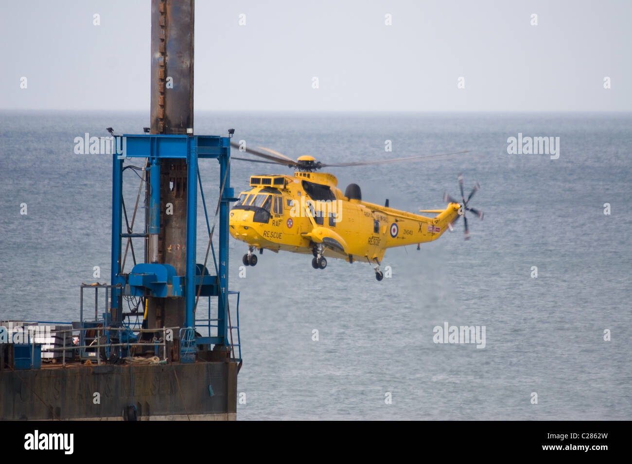 Eine RAF Westland Sea King HAR3/3A schwebt in der Nähe eine Buchse Plattform/Rig während der Durchführung einer Rettungs vor der Küste von Norfolk UK. Stockfoto