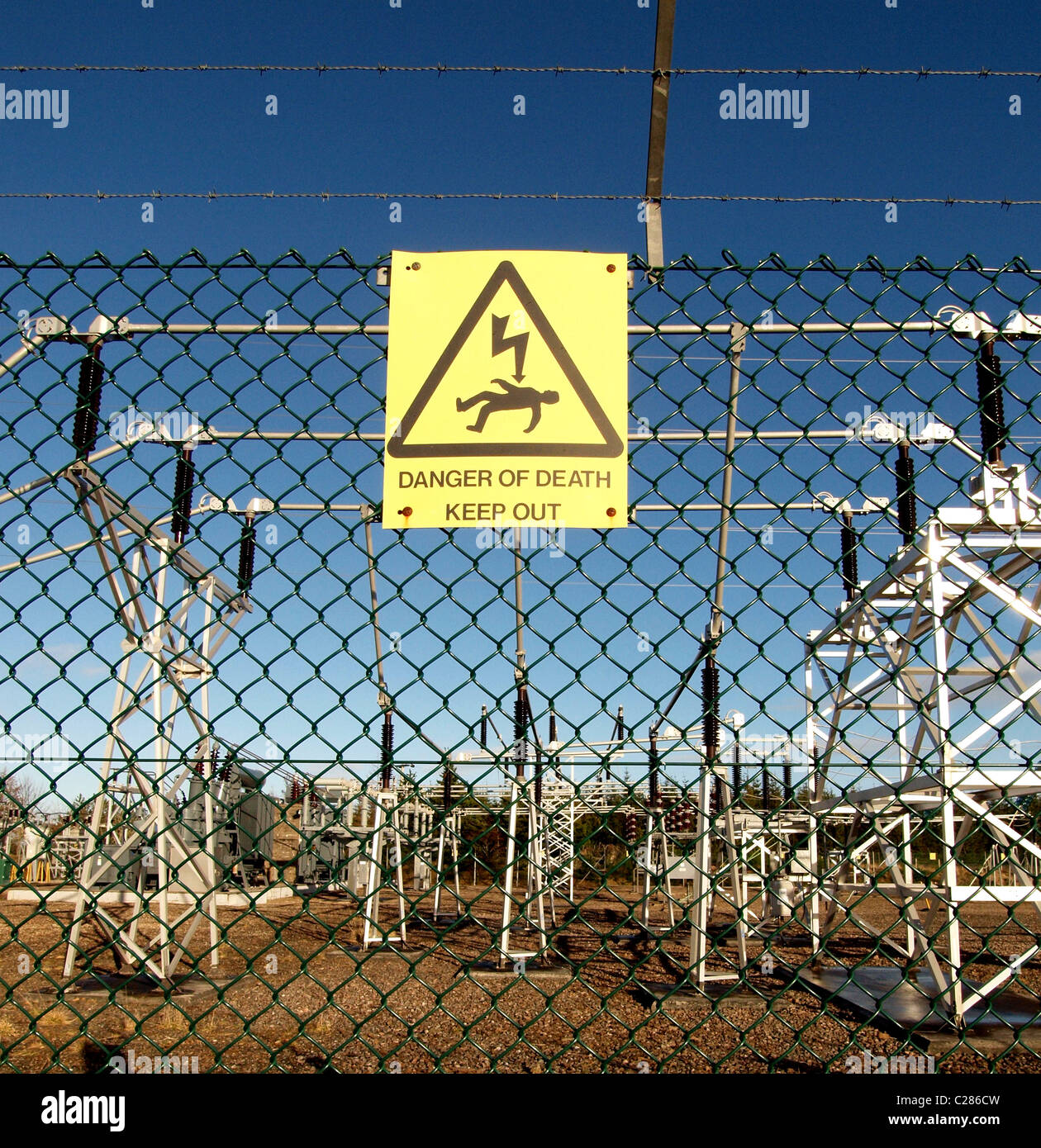 Ein Umspannwerk mit Gefahrenzeichen, angrenzend an einen großen schottischen Windpark. Stockfoto