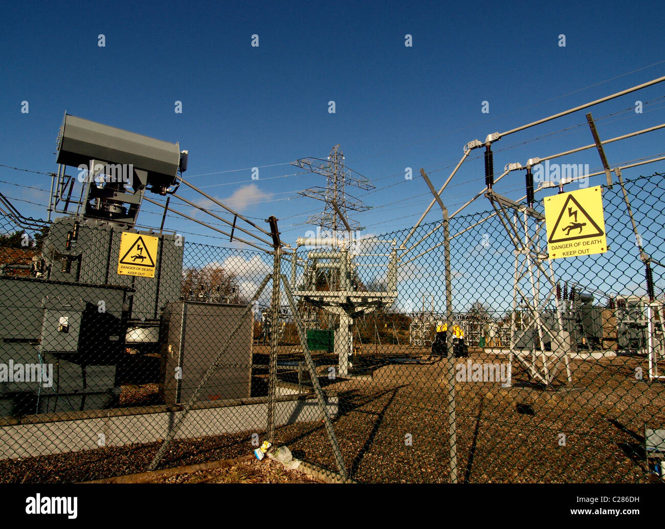 Ein Umspannwerk mit Gefahrenzeichen, angrenzend an einen großen schottischen Windpark. Stockfoto