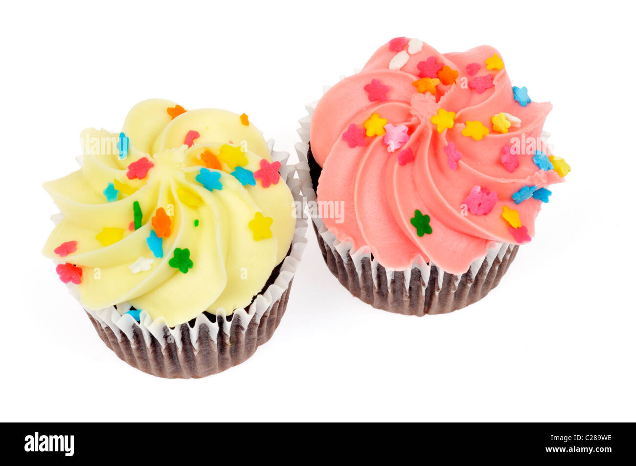 Gelben Zitronen und rosa Beeren Geeistes Schokoladen Cupcakes dekoriert mit Streuseln auf weißem Hintergrund isoliert. Stockfoto
