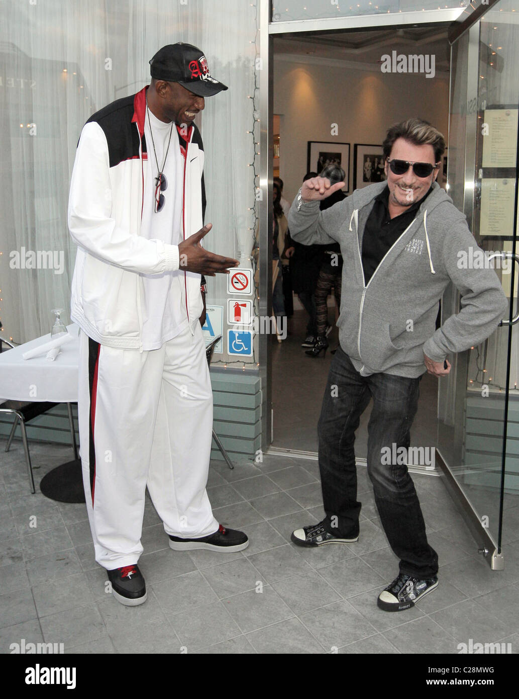 LA Laker D. J. Mbenga und Johnny Hallyday Johnny Hallyday und seine Frau Laetitia, zu Mittag mit LA Laker D. J. Mbenga an Stockfoto