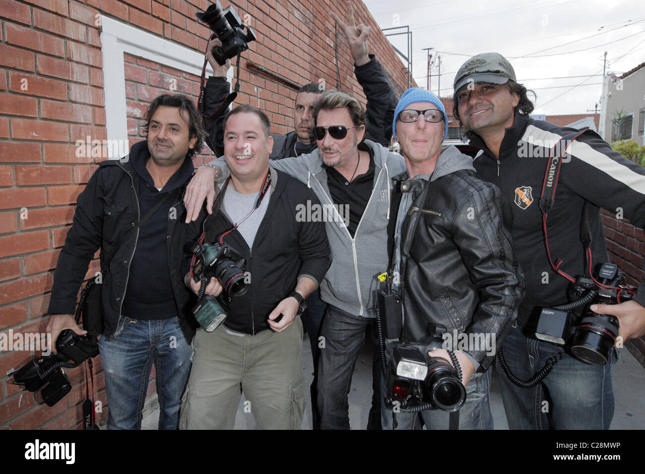 Johnny Hallyday posiert mit Fotografen, nach dem Mittagessen mit seiner Frau Laetitia und LA Laker D. J. Mbenga bei Petrossian auf Stockfoto