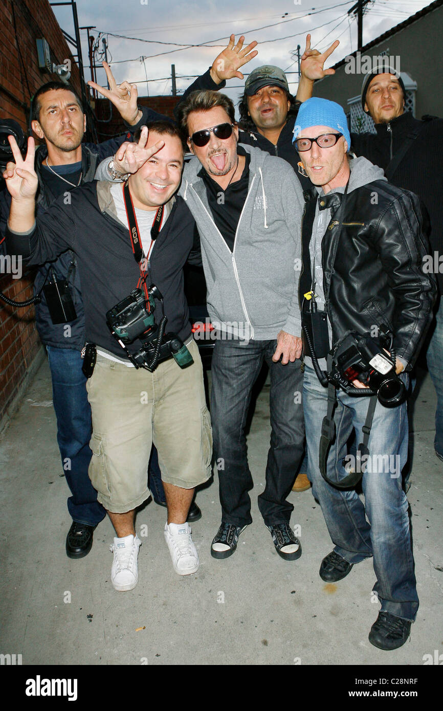 Johnny Hallyday posiert mit Fotografen nach dem Mittagessen mit seiner Frau Laetitia und LA Laker D. J. Mbenga bei Petrossian auf Stockfoto