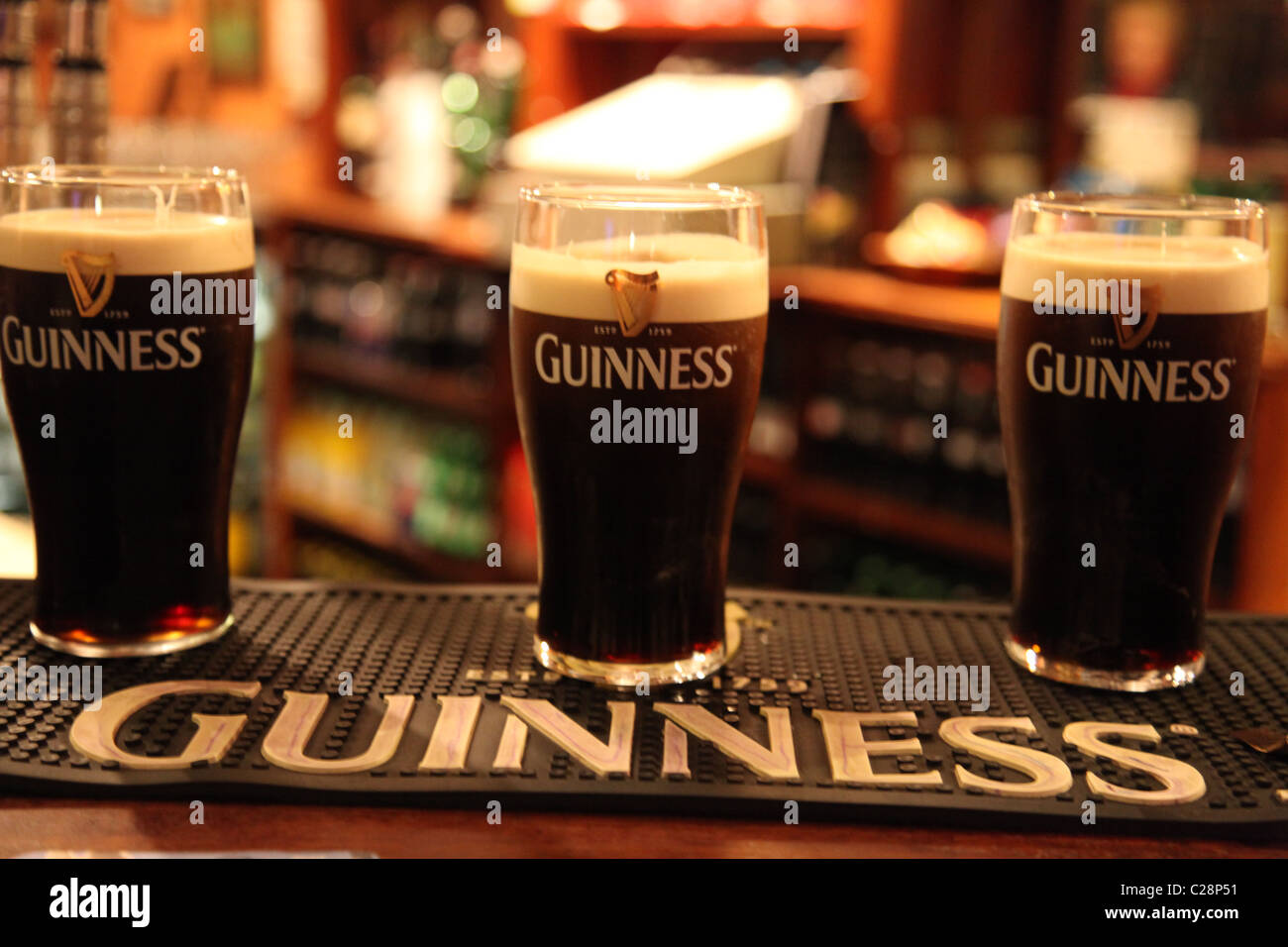drei Pints Guinness aufgespielt auf eine Bar Theke in eine irische bar Pub Stockfoto