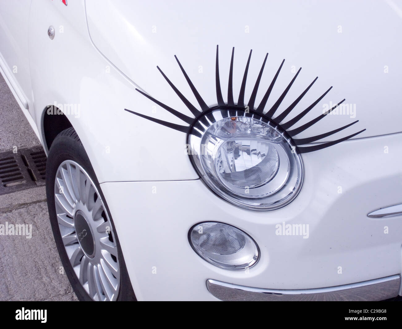 Scheinwerfer von einem weißen Fiat 500-Auto mit großen künstlichen  Augenbrauen ausgestattet Stockfotografie - Alamy