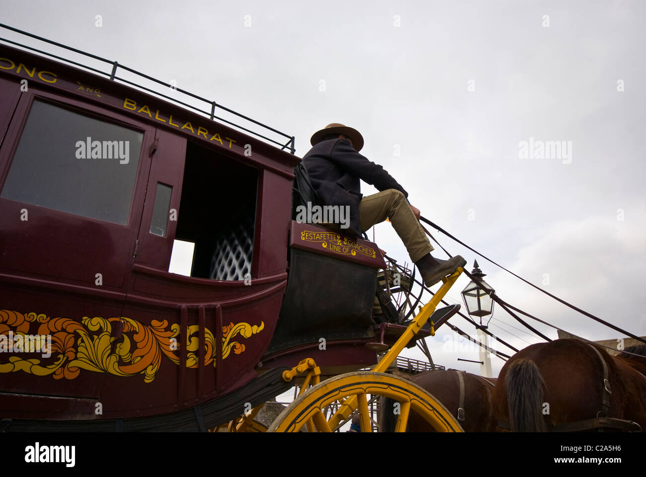 Ein Kutscher fährt eine Postkutsche und Pferdegespann. Stockfoto