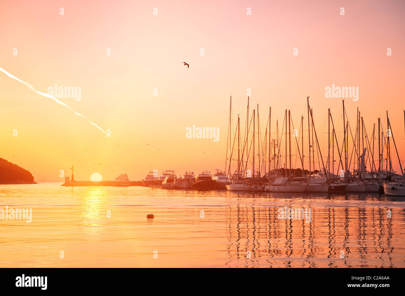 Yachten und Boote auf dem Adriatischen Meer der Bucht bei Sonnenuntergang in goldenen und rosa Tönen. Vrsar, Kroatien, beliebtes Touristenziel. Stockfoto