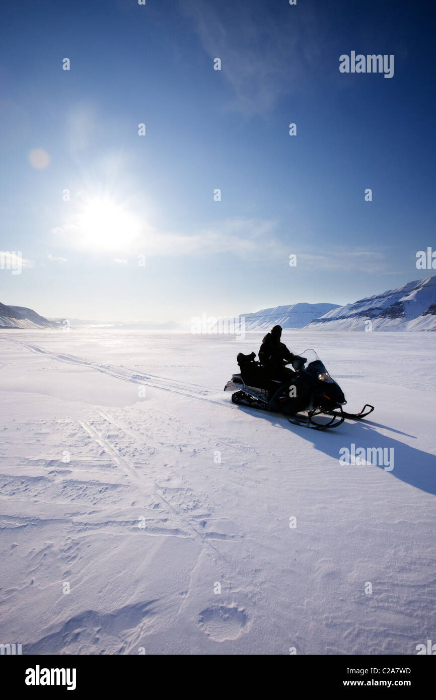 Ein Schneemobil auf gefrorenen Eis auf einer kargen Winterlandschaft Stockfoto