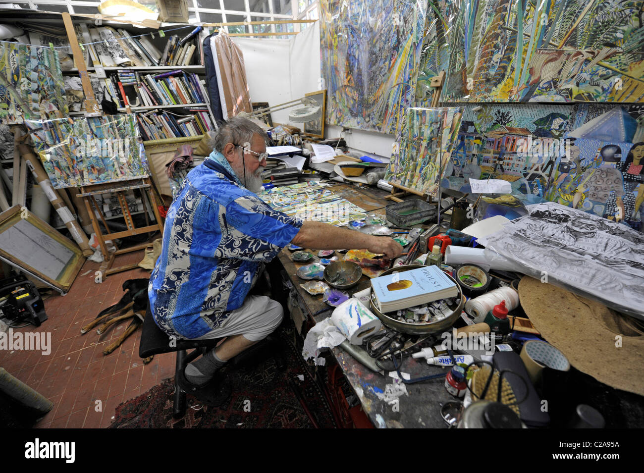Maler Michael Adams sitzt in seinem Atelier in Anse C-Jugend Bleues, Insel Mahé, Seychellen Stockfoto