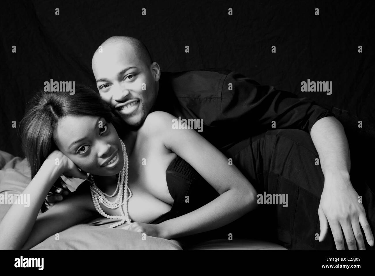 Schöne afrikanische amerikanische paar faulenzen, beide lächelnd mit Freude, in schwarz und weiß Stockfoto