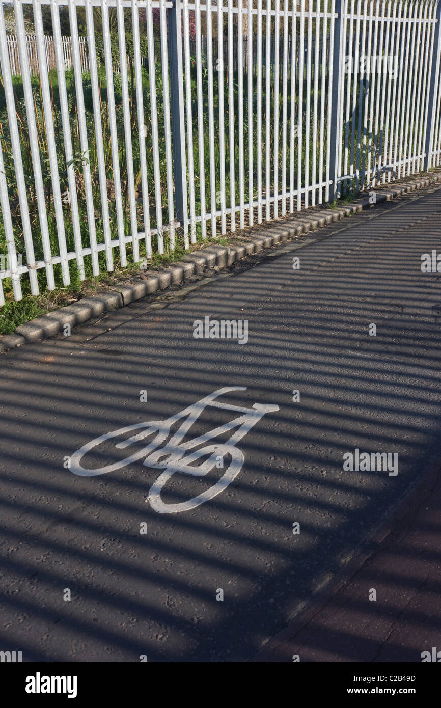Ein pendeln Radfahrer fährt neben sonnigen Geländer auf eine Rennstreckenareal in Kennington, Südlondon. Stockfoto