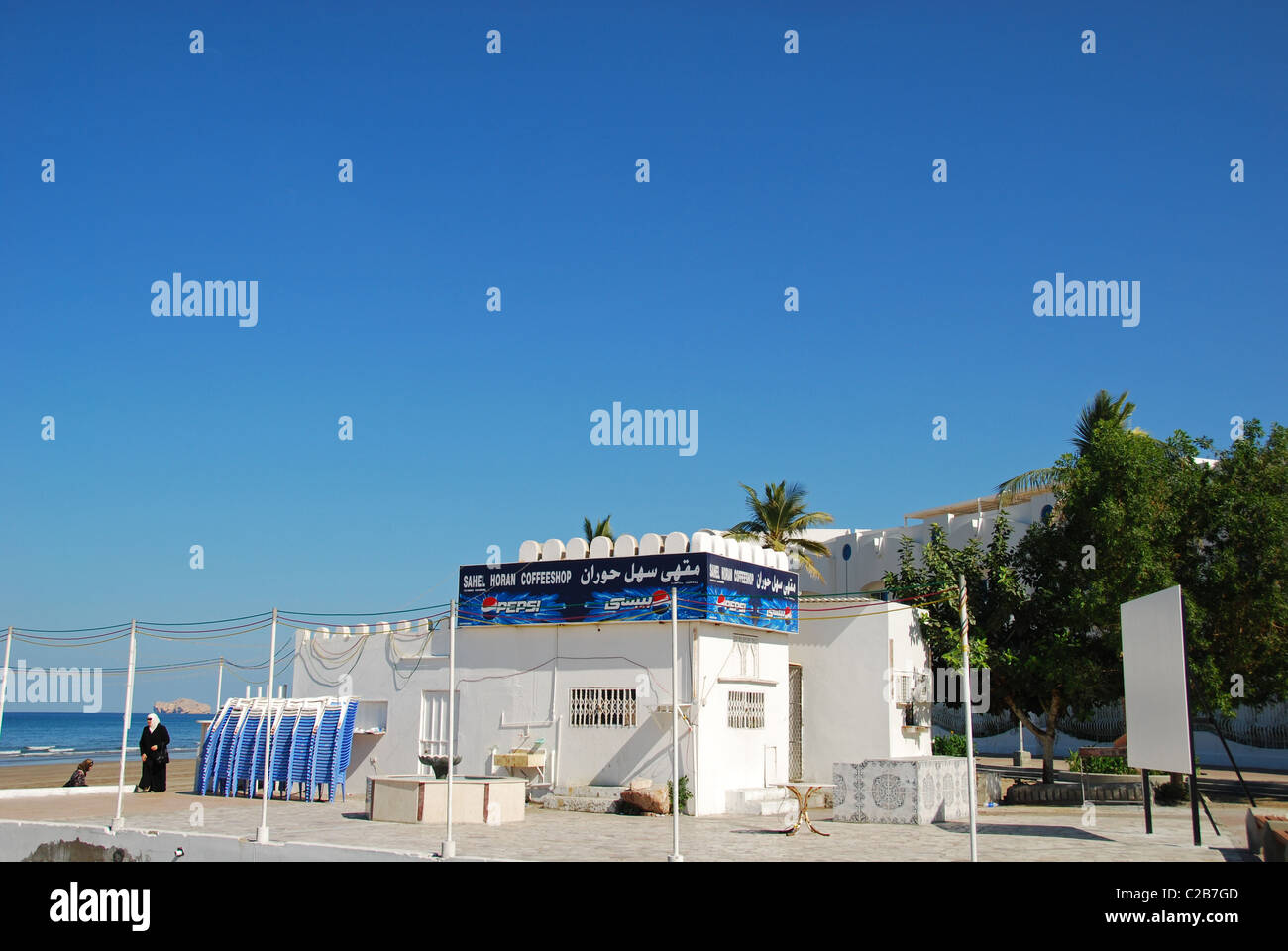 Oman, Maskat, zwei Frauen zu Fuß durch das Café am Strand an einem sonnigen Tag Stockfoto