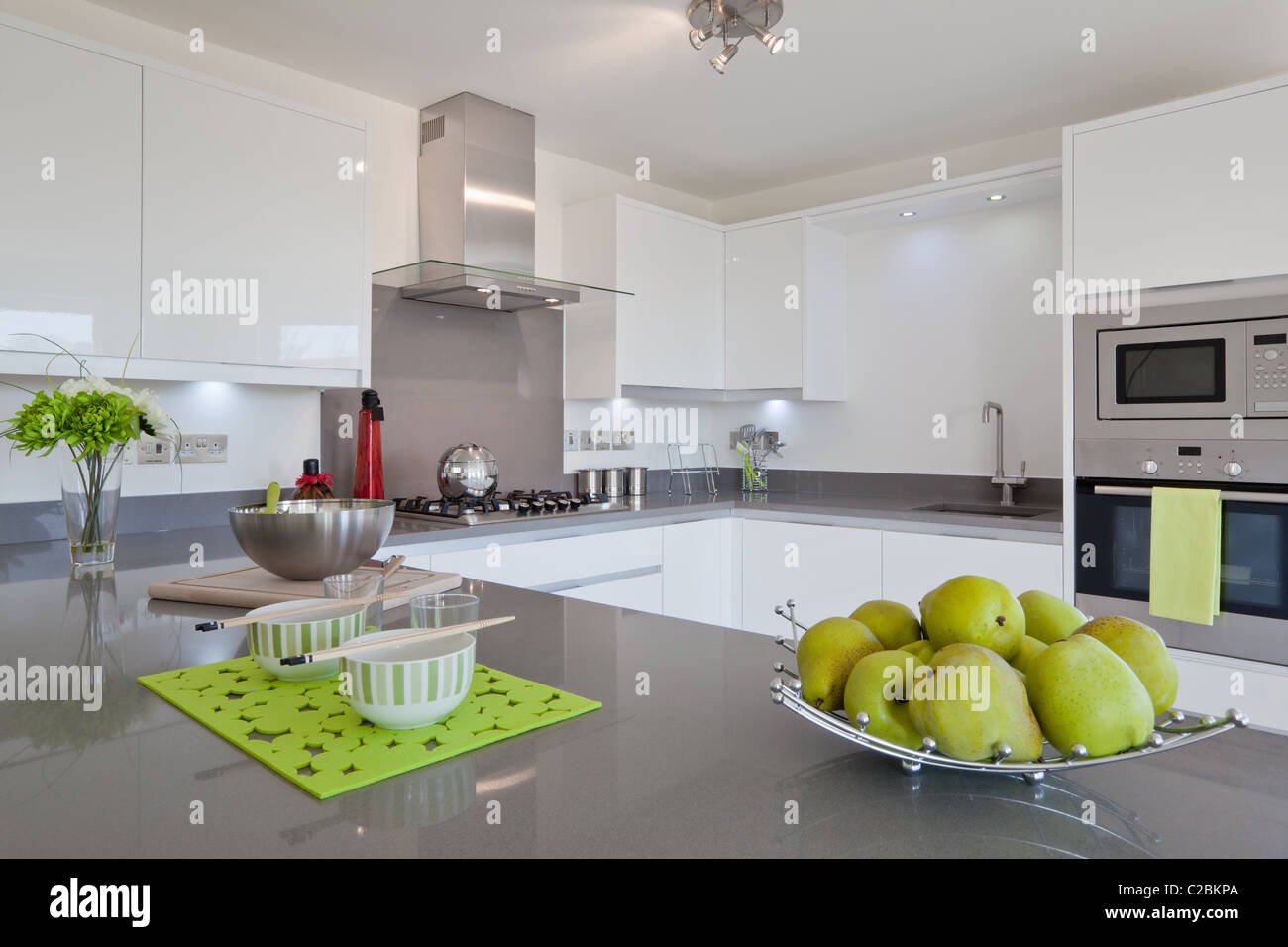 Neu Anbauküche moderne mit eingebauten Geräte, Geschirr und Obstkorb Stockfoto
