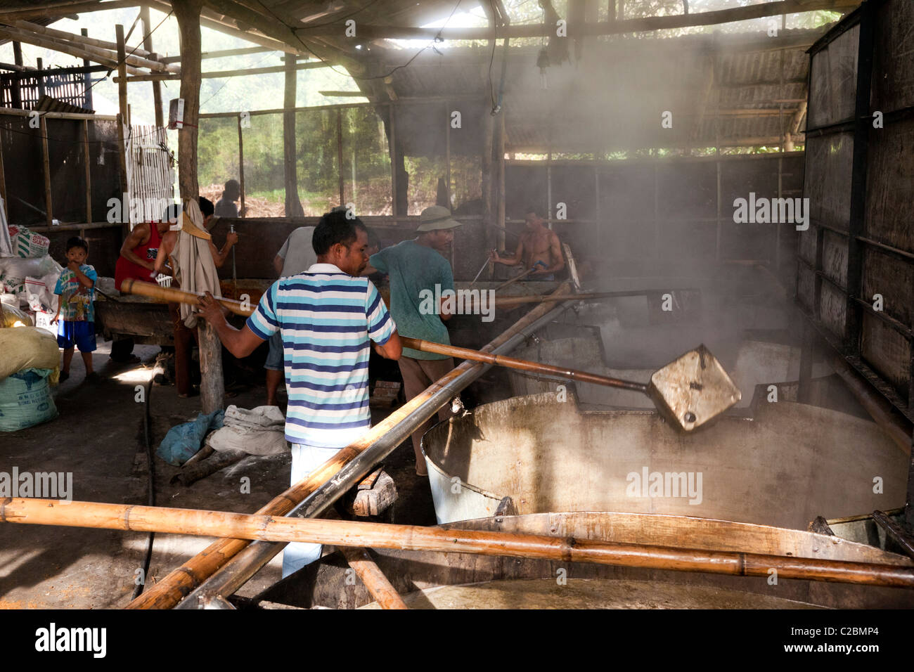 Philippinische Arbeiter Verarbeitung Muscovado-Zucker in großen Fässern an eine Zuckerfabrik. Die Philippinen Stockfoto