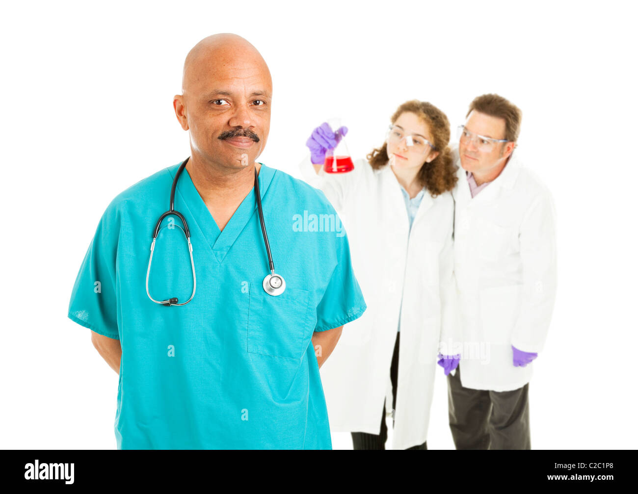 Gut aussehend afrikanisch-amerikanischer Chirurg mit Labor-Techniker im Hintergrund. Isoliert auf weiss. Stockfoto