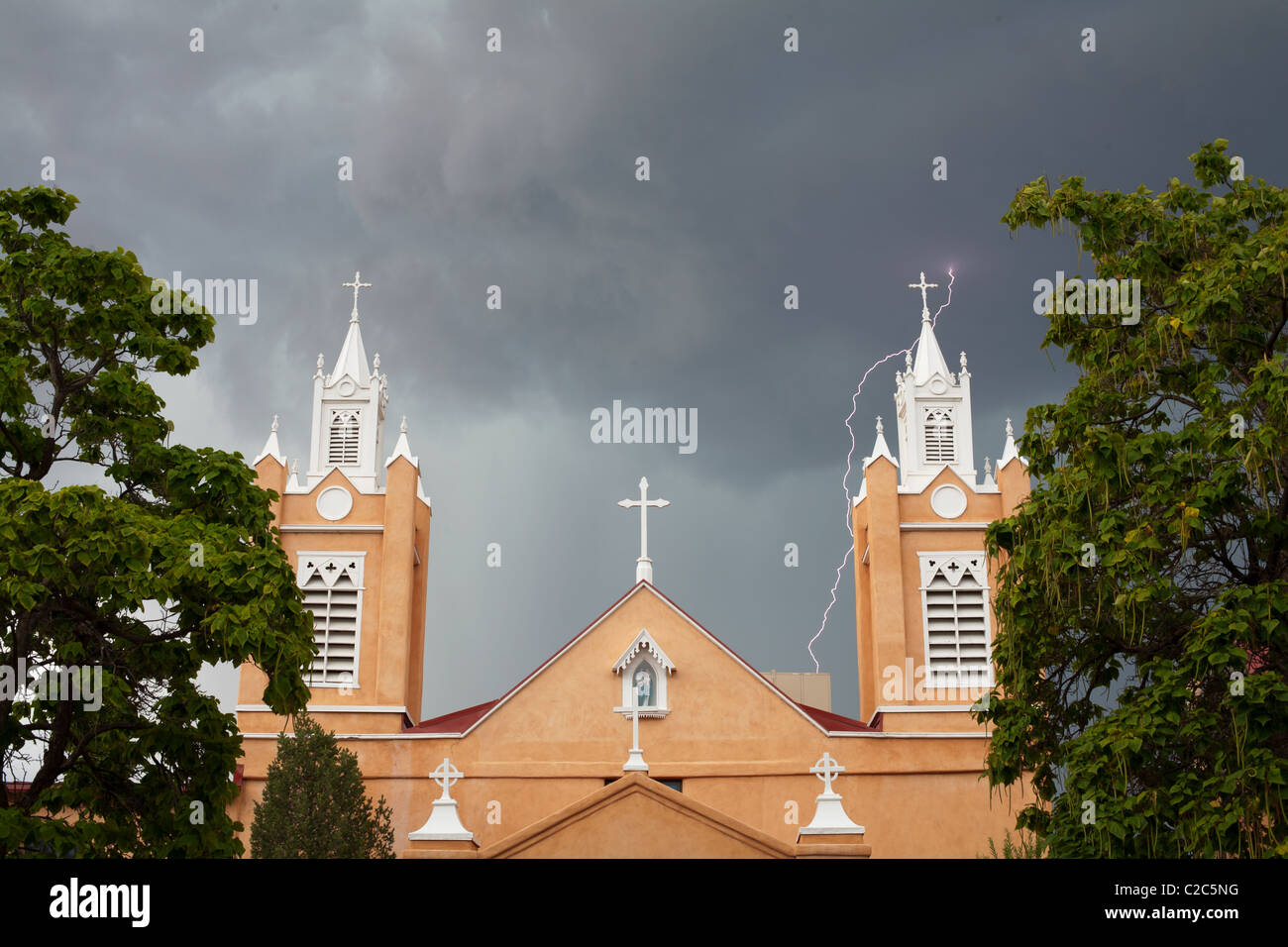 Kirche San Roulé de Neri in der Altstadt von Albuquerque. Hinter der Kirche fällt ein Blitzlicht auf. Bernalillo County, New Mexico, USA. Stockfoto