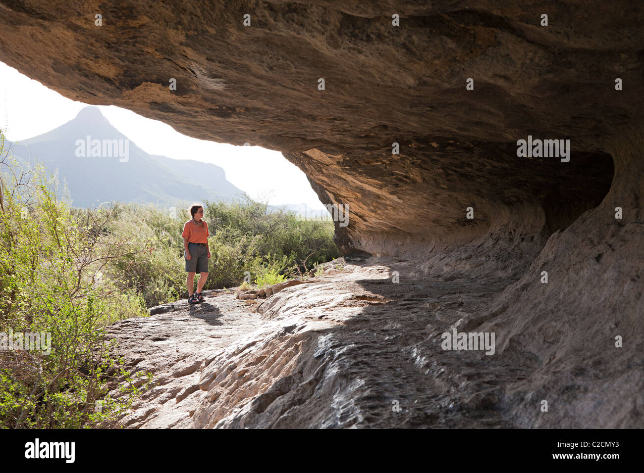 Person, die bei Cuevas Amarillas Urgestein Unterschlupf Big Bend Ranch State Park Texas USA Stockfoto