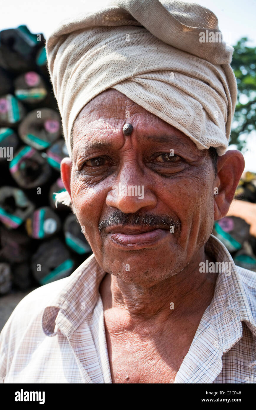 Indien-Mann stand vor Protokollen an einem Holzlagerplatz, Fort Kochi, Kerala, Indien Stockfoto