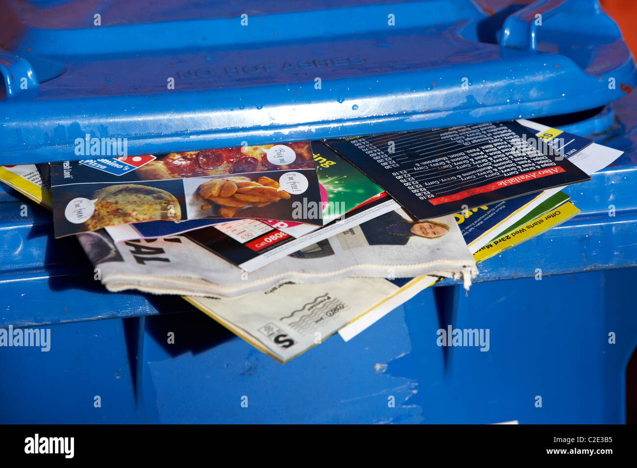 blaues Papier recycling Behälter mit Junk-Mail und lokale Zeitungen kleben aus ihm heraus und Deckel nicht geschlossen im Vereinigten Königreich Stockfoto