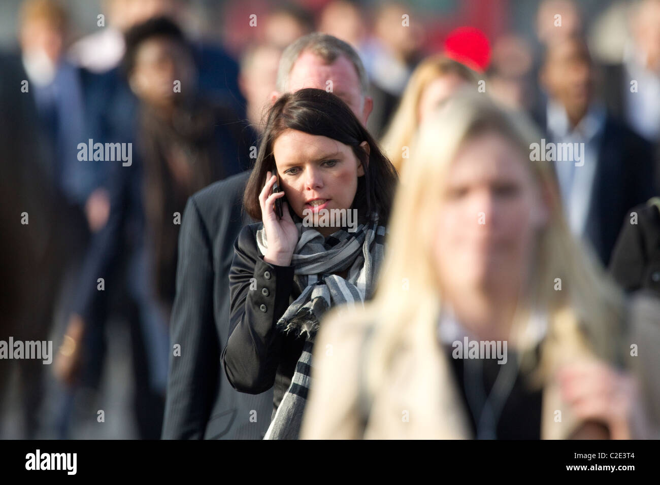 Frau am Handy unter Pendler im Berufsverkehr, London Bridge, England, UK. Foto: Jeff Gilbert Stockfoto
