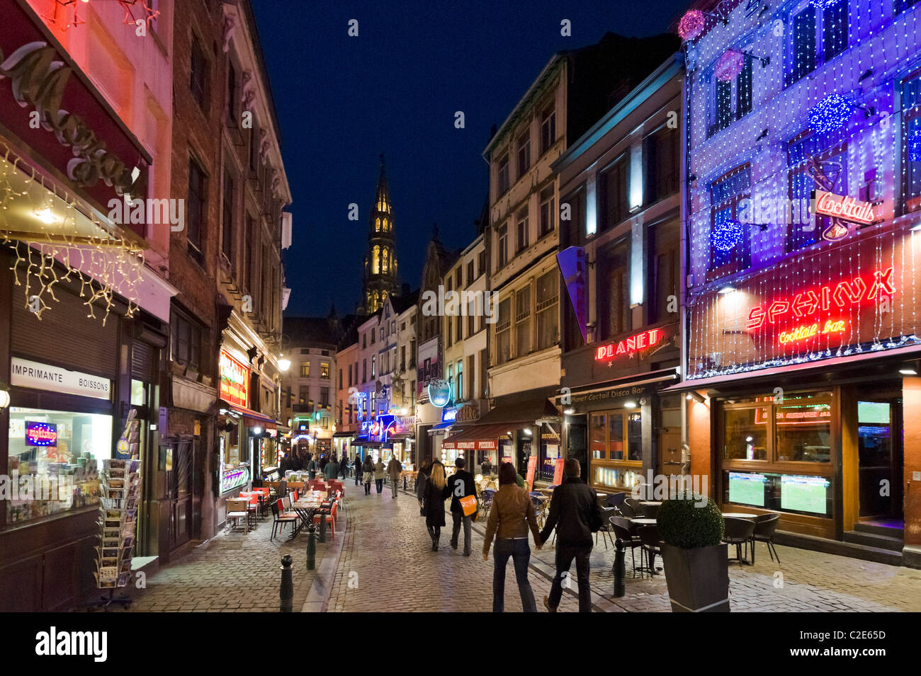 Bars und Restaurants in der Nacht auf der Rue du Marche Aux Fromages mit dem Turm des Hotel de Ville hinter, Brüssel, Belgien Stockfoto