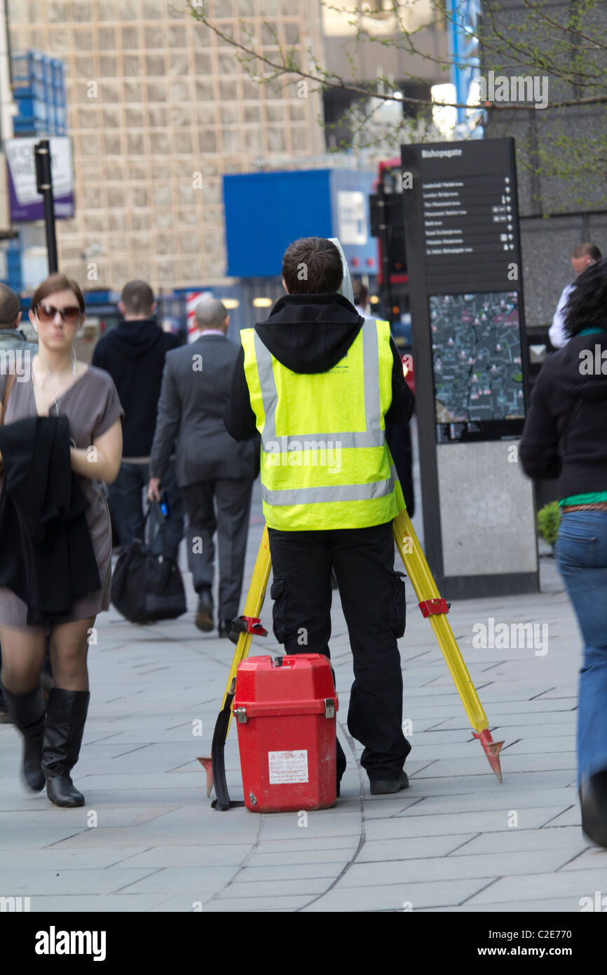 Vermesser mit Theodolit in der belebten Straße im Zentrum von London, Großbritannien Stockfoto
