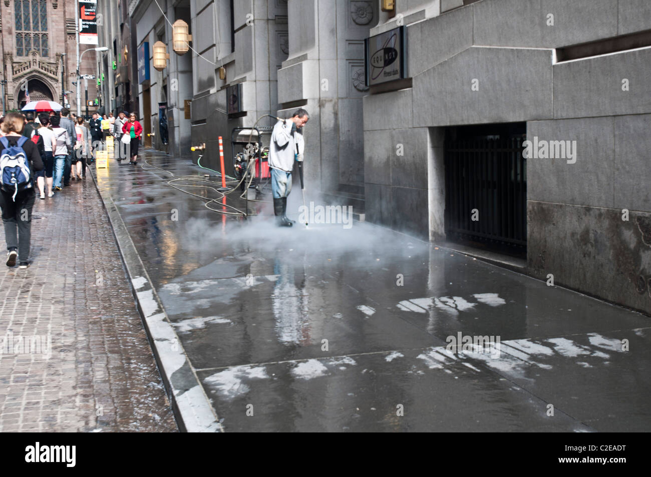 Arbeitnehmer mit hohem Druck Wasser Kaugummi Entfernung Maschine vom Gehweg, Wall Street, Manhattan, New York City, USA Stockfoto