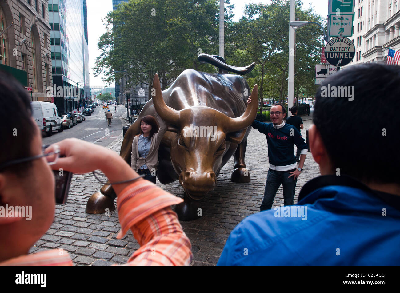 Gruppe von Touristen fotografieren bei Aufladung Bull. Wall Street Bull oder Bowling Green Bull Bronzestatue, Financial District, NYC Stockfoto