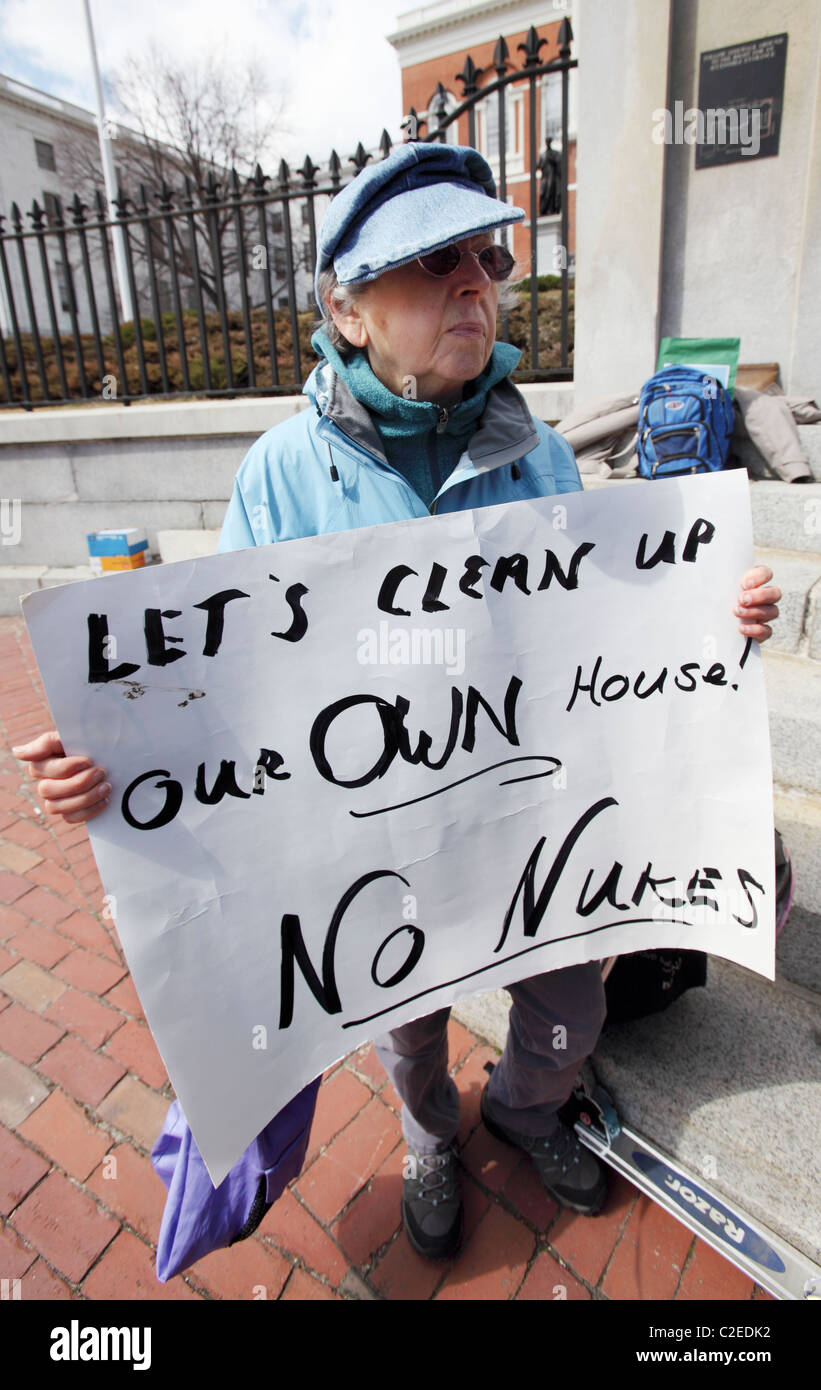 Eine Frau hält ein Schild während einer Anti-Atom-Kundgebung vor dem State House in Boston, Massachusetts Stockfoto