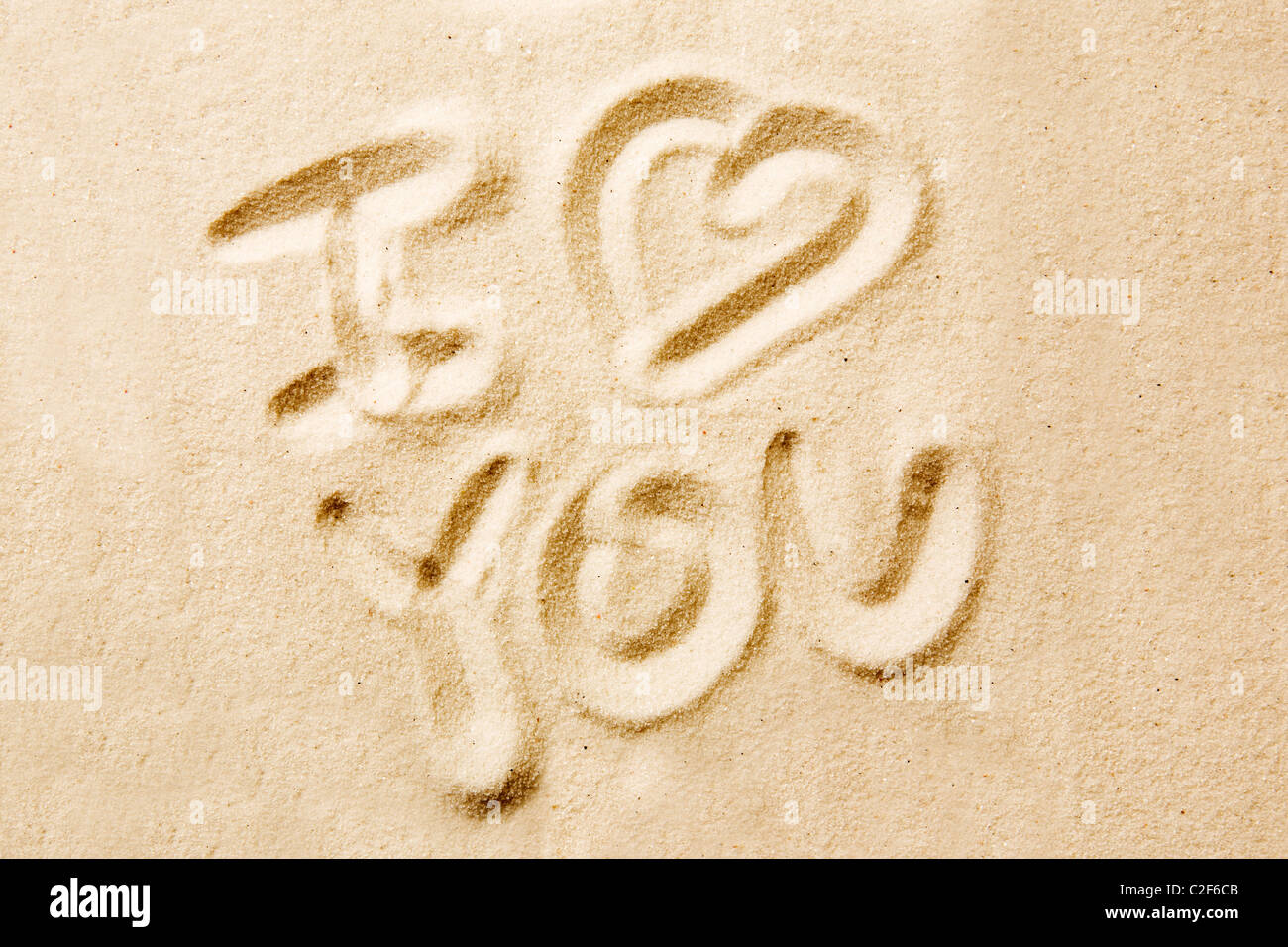 Ich liebe Sie Nachricht geschrieben in goldenem sand Stockfoto
