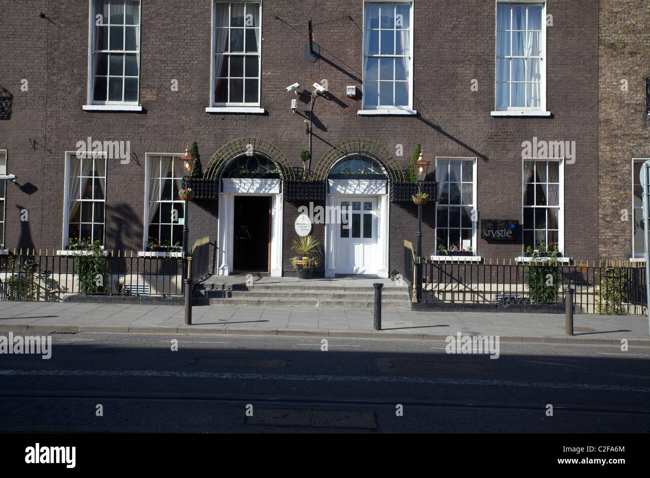 Beiden vorderen Türen des georgianischen Gebäuden verfolgt man mit einer weißen Tür und das andere mit einem schwarzen Tor mit Luas im Vordergrund Stockfoto