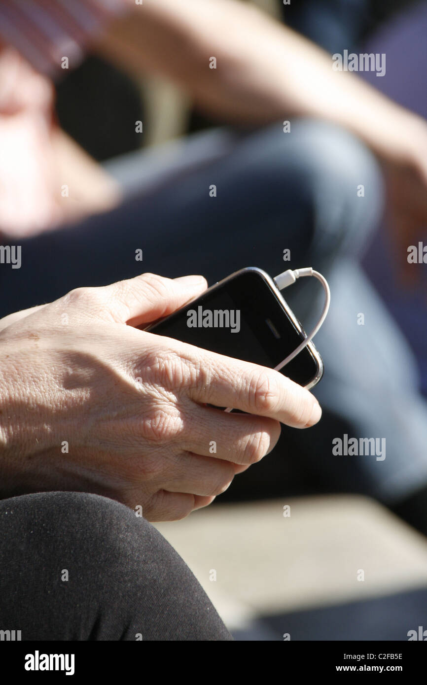 Detail der Frau mit Iphone in Sonne im freien Stockfoto