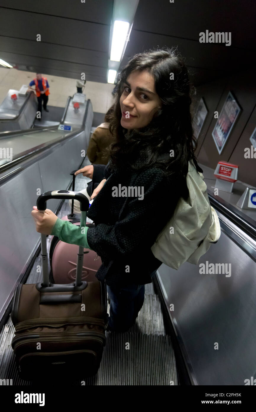 Frau mit einer Rolltreppe herab Reisegepäck Stockfoto