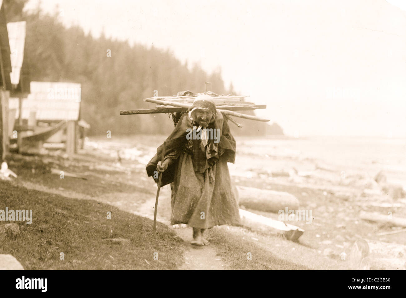 Makah Seniorin mit Reisig, ein Bündel von Stöcken, auf dem Rücken, bei Neah Bay, Washington Stockfoto