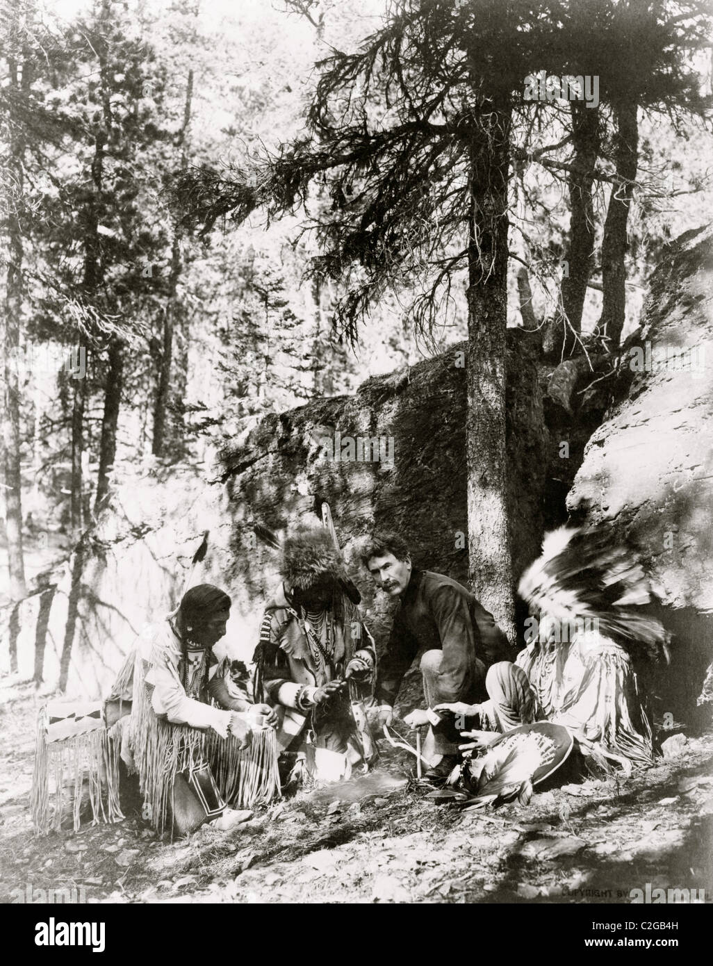 Ernest Thompson Seton, mit drei Blackfeet Indianer, zeigen, wie man ein Feuer entfachen Stockfoto
