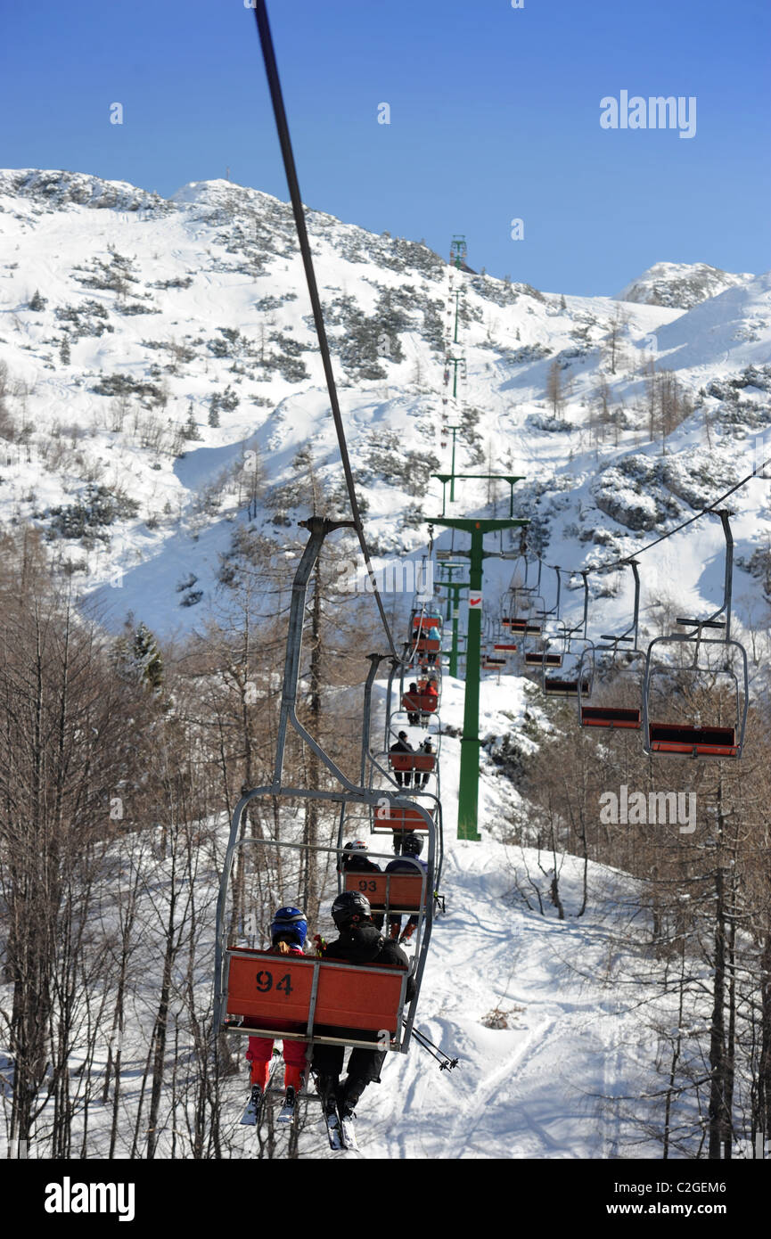 Skifahrer auf dem Sessellift auf das Skizentrum Vogel von der Basis der Sija - Zadnji Vogel Piste im Triglav National Park von Slo Stockfoto