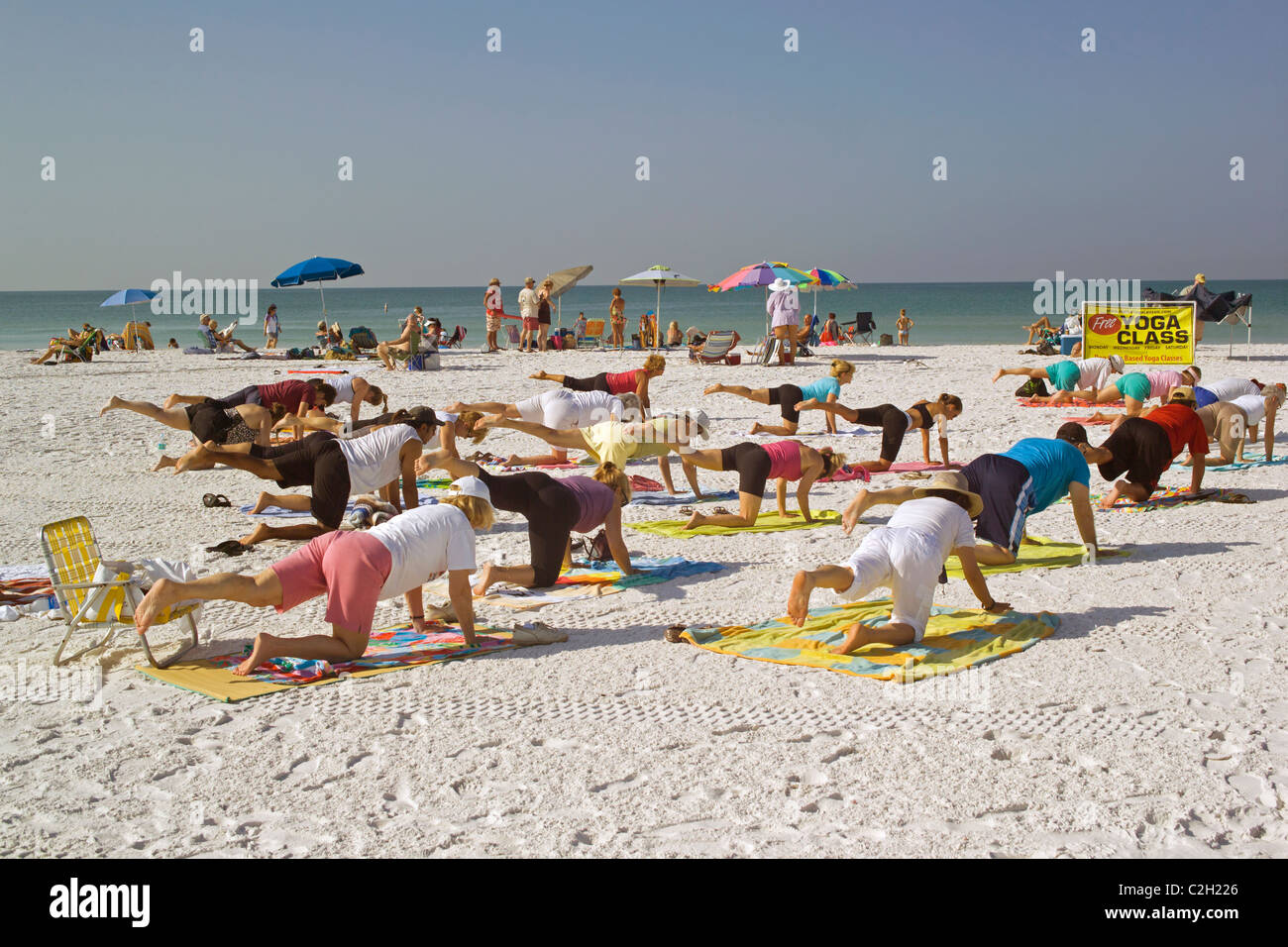 Yoga-Kurse sind auf den weißen Sand Strand von Siesta Key, ein Resort vorgelagerten Insel am Golf von Mexiko in Sarasota, Florida statt. Stockfoto