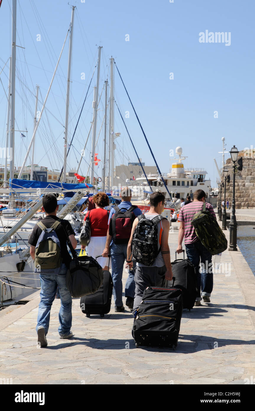Reisende schleppen ihr Gepäck zum Fährhafen am Hafen von Kos-Stadt auf der Insel Kos Griechenland Stockfoto