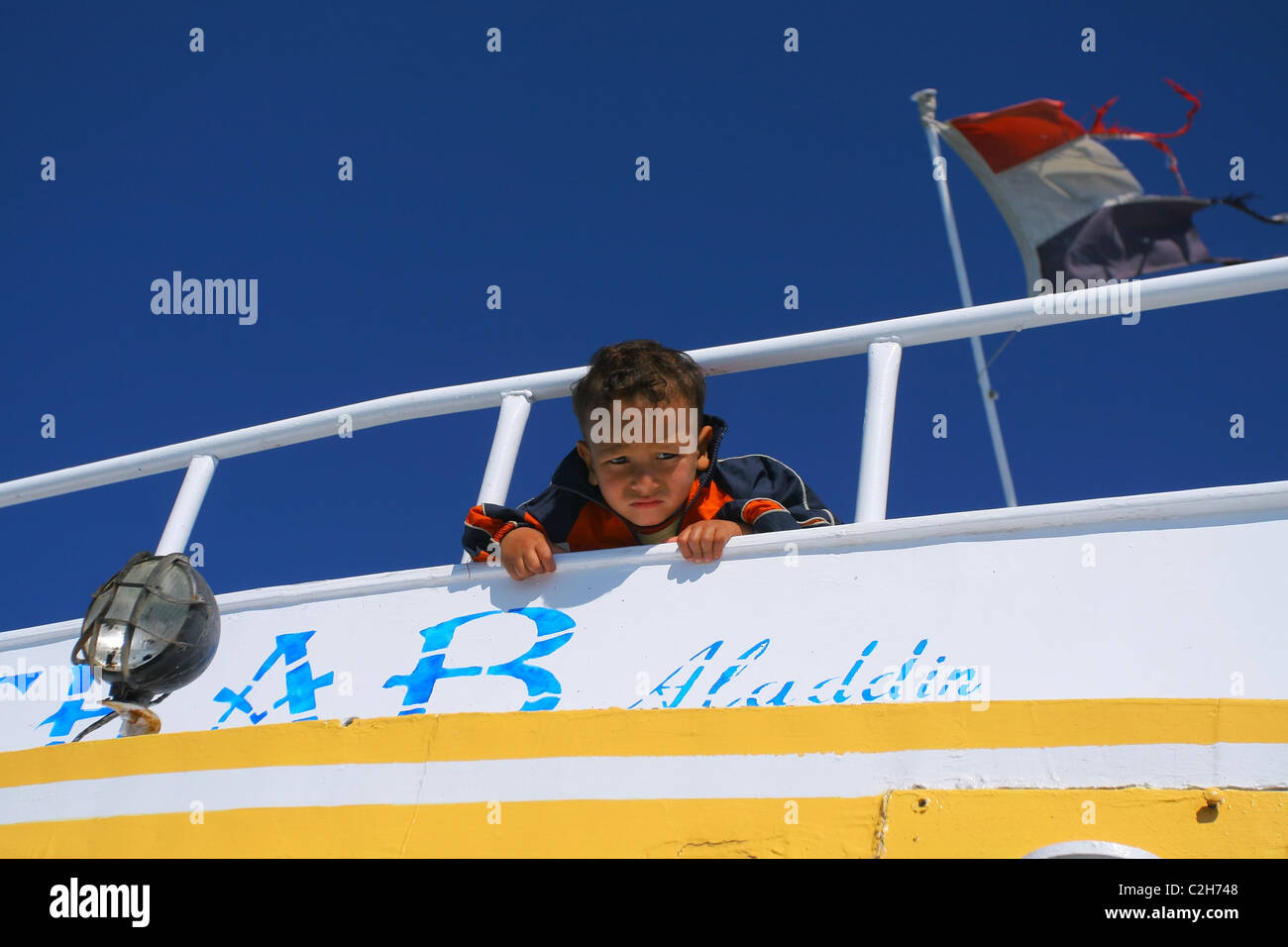 Traurige kleine Junge blickte von dem der Vorstand des Bootes. Port Safaga, Rotes Meer, Ägypten Stockfoto