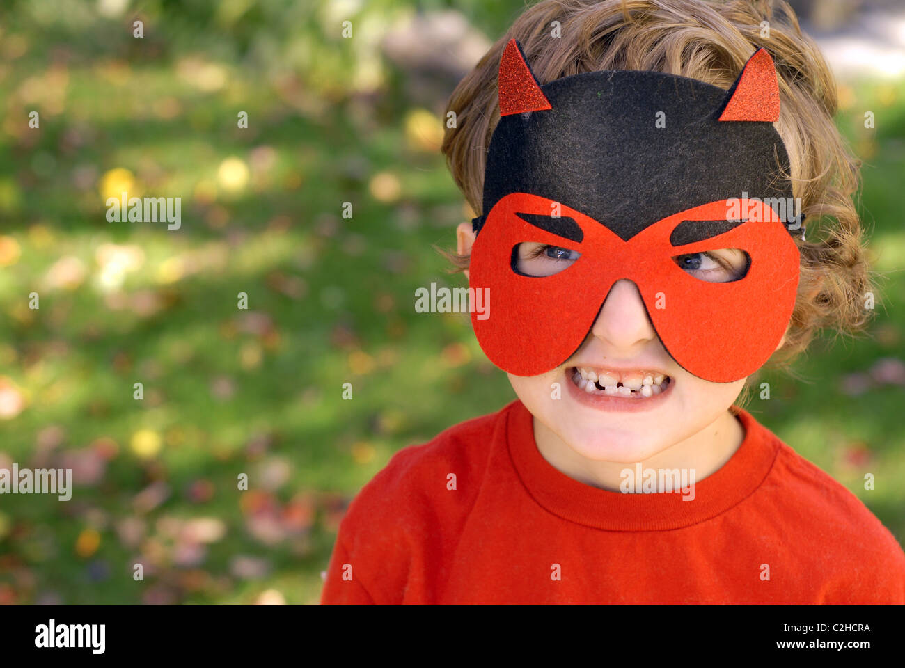 Sechs-jährige weiß, kaukasische junge mit blonden Haaren und blauen Augen mit einem Teufel Maske für Halloween. Stockfoto