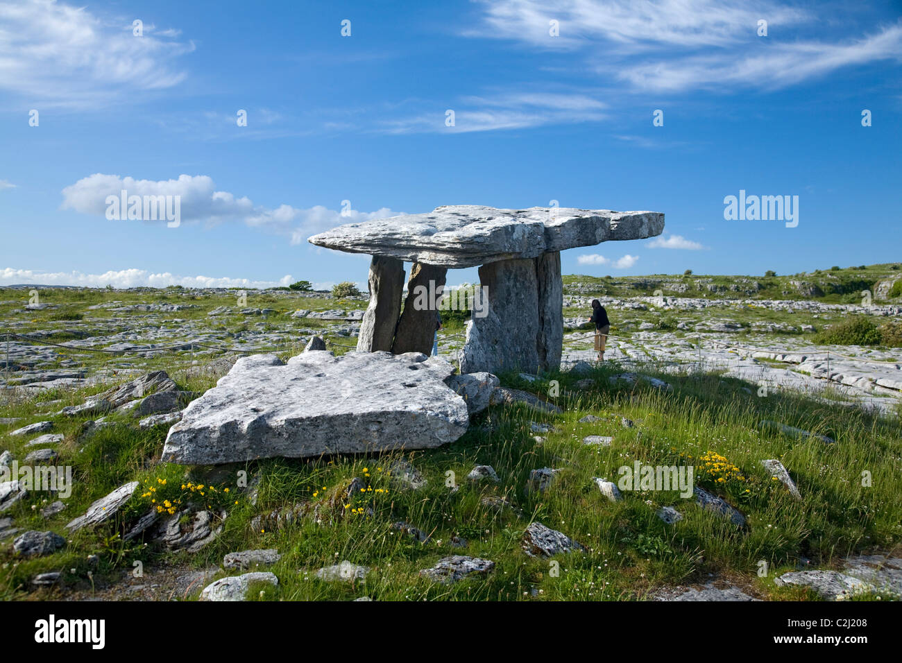 Person neben Poulnabrone Dolmen, die Burren, Co Clare, Irland. Stockfoto