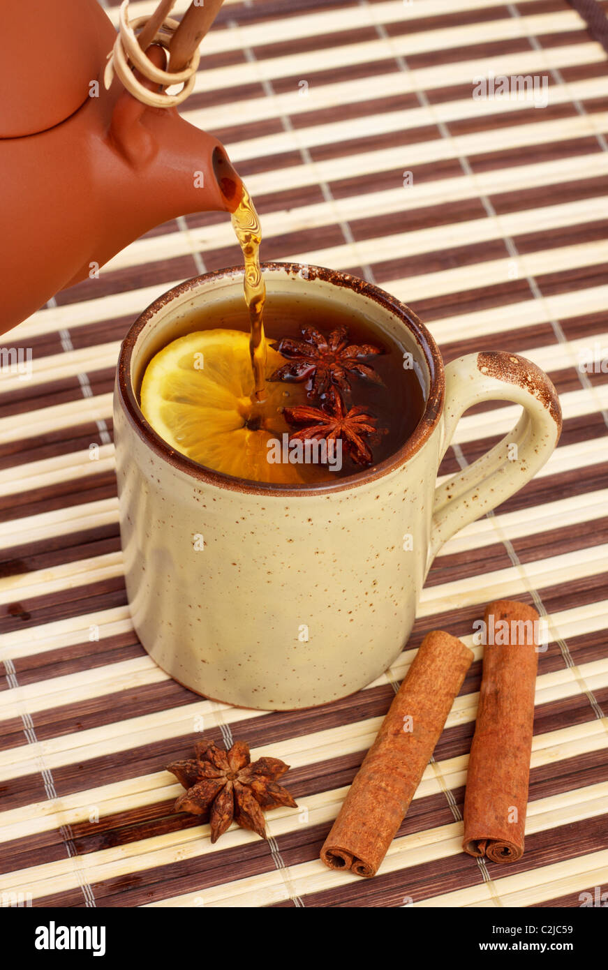 Tee in Tasse mit Zimt und Sternanis auf Bambus Serviette gießen Stockfoto