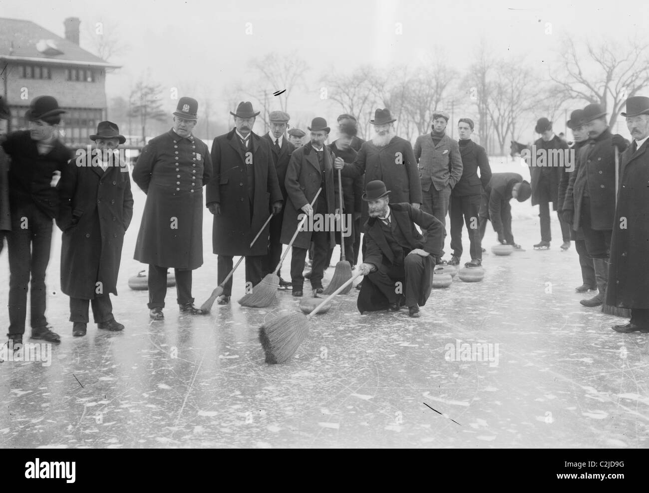 Eisstockschießen im Central Park mit Männern mit Besen bereit über das Eis. Stockfoto
