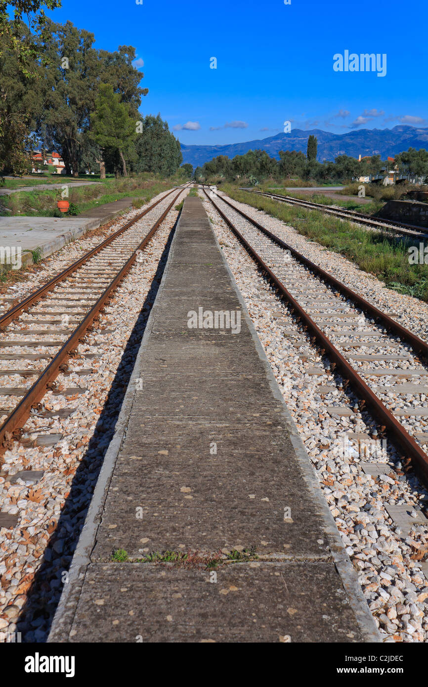 Rostig und verlassenen Bahnhof wettert gegen blauen Himmel und Bäume Stockfoto