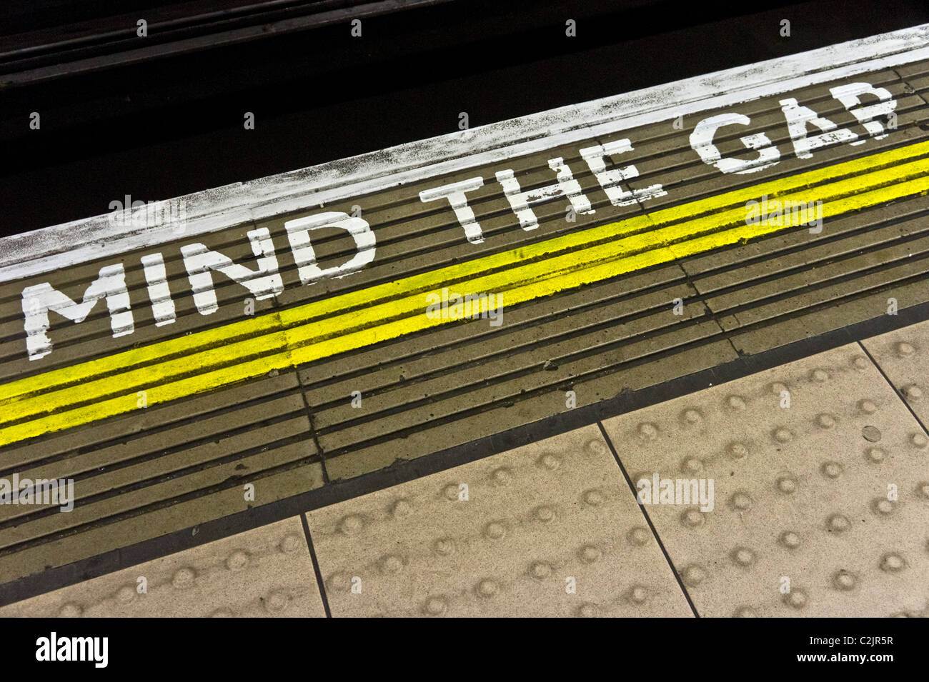 Dagegen Sie die Lücke Warnung am Rande einer u-Bahnstation Plattform, London, England Stockfoto