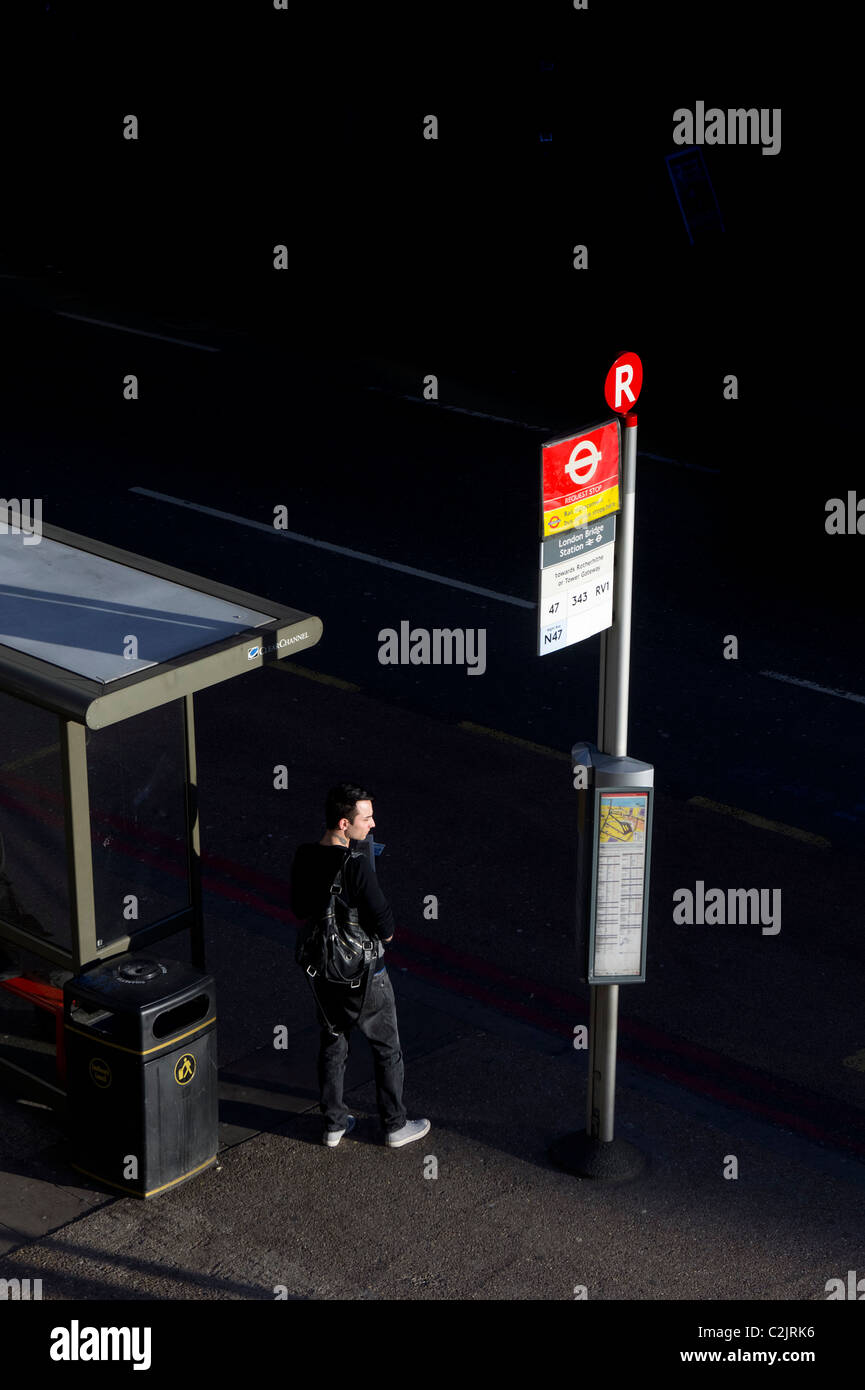 Mann warten auf Bus in London Bridge Station Bushaltestelle, London, England, UK Stockfoto