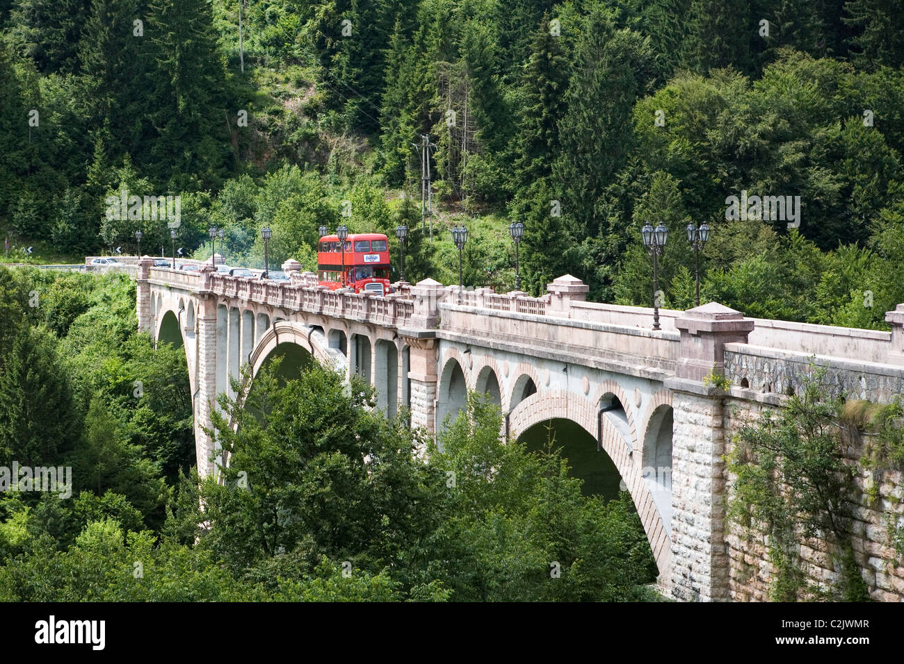 London red Bus überqueren einer Brücke in den grünen Wald in Italy.Transport für London Routemaster dient zur Hochzeit Gues transportieren Stockfoto