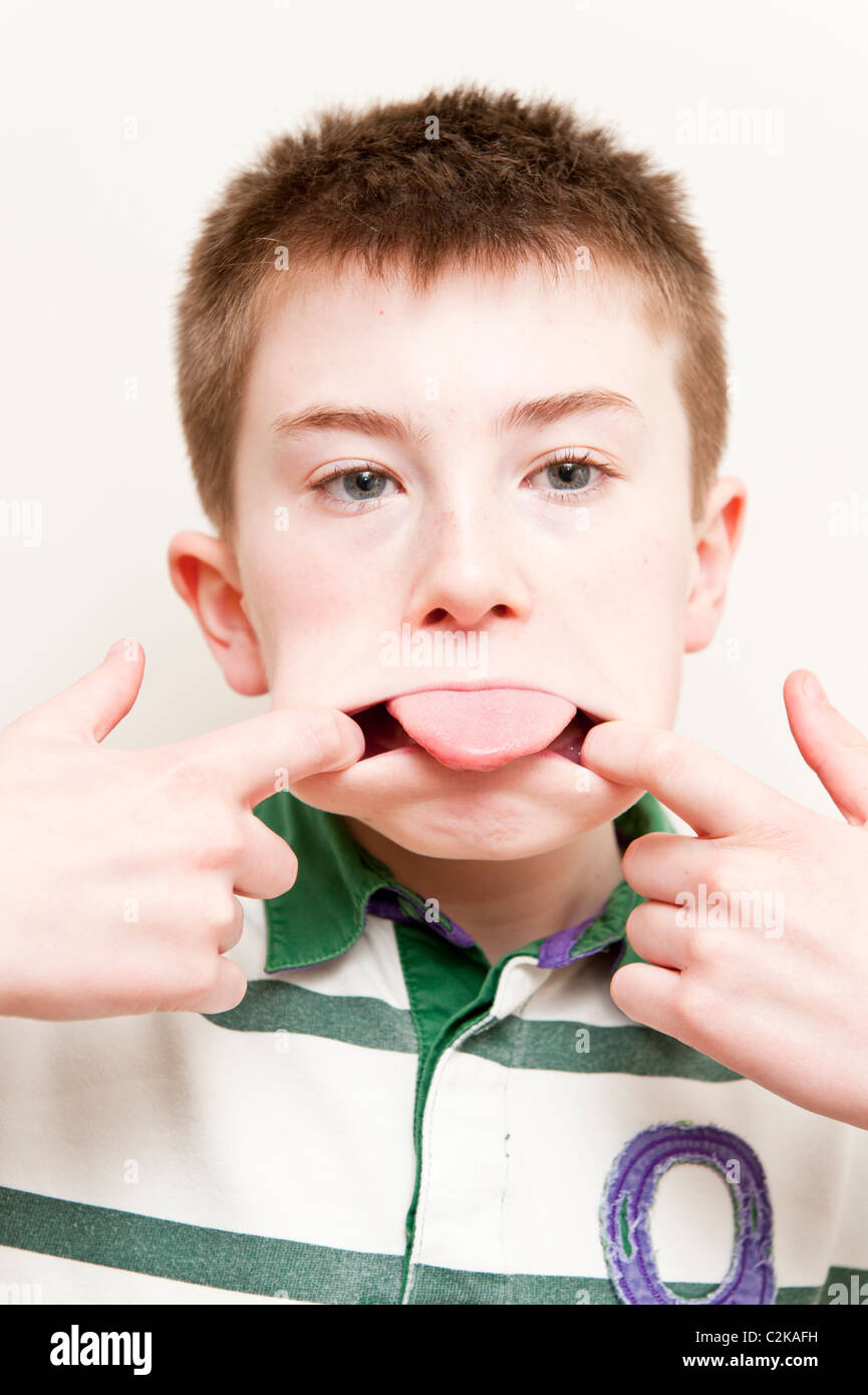 Ein MODEL Release Bild eines elfjährigen Jungen ziehen ein lustiges Gesicht im Innenbereich Stockfoto